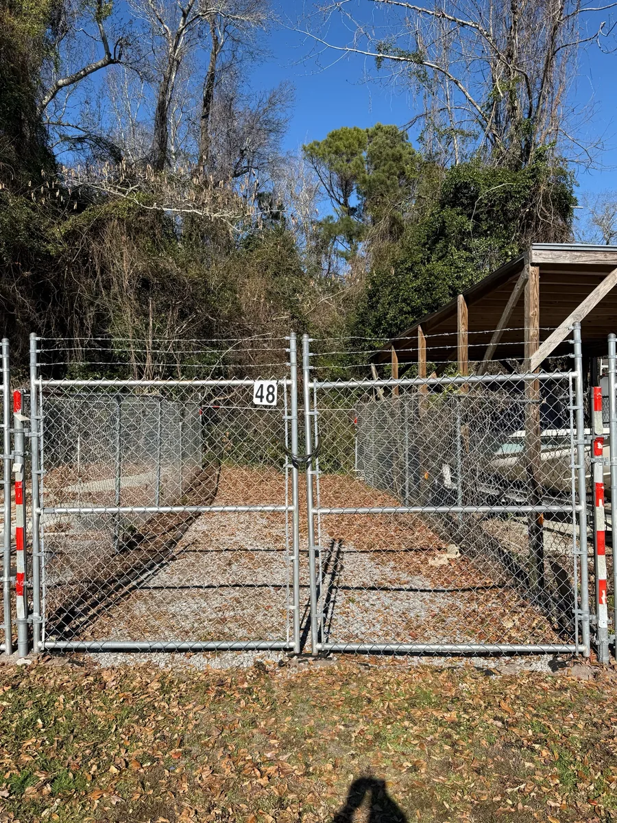 Gated storage space 48 beside a wooden boat shelter